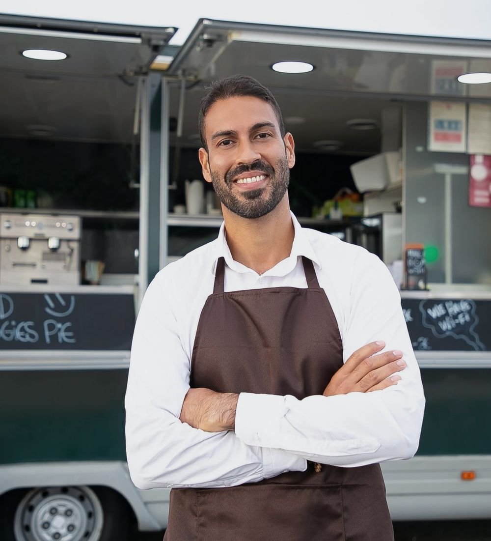 Business owner standing in front of his food truck