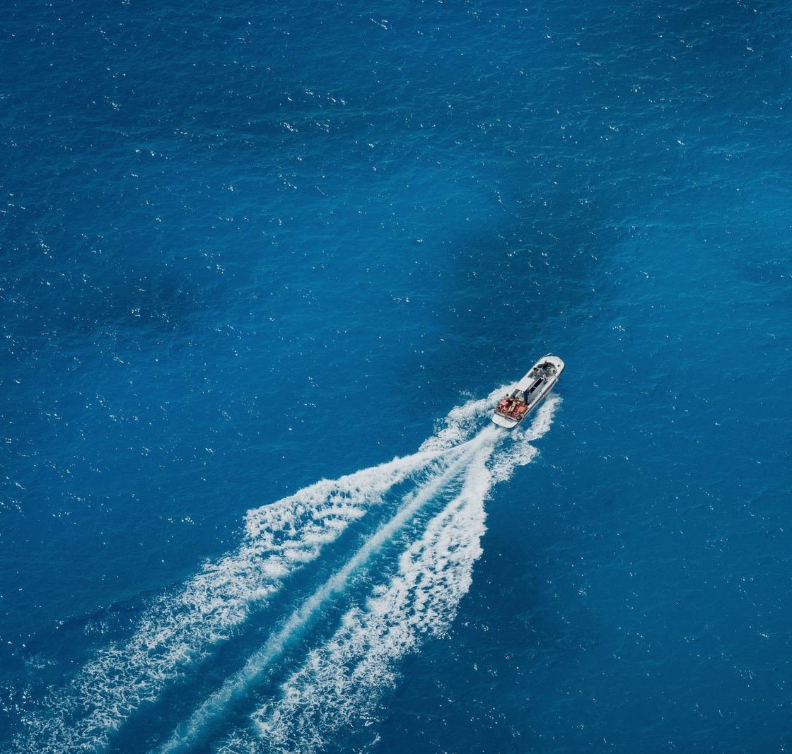 Speedboat cutting across open water, seen from above